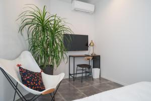 a room with white chairs and a desk with a tv at INFINITY HOTEL -Higawa- in Naha