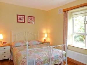 a bedroom with a white bed and a window at Hollyglen House in Common Bridge