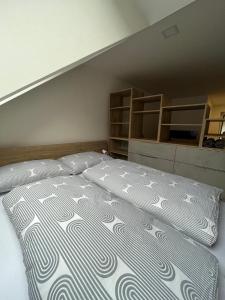 a large bed in a room with an attic at Apartmany CityCentrum Trencin in Trenčín