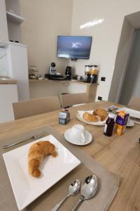 ein Tisch mit einem Teller und einem Laib Brot darauf in der Unterkunft GioielliPlace in Capodrise + 23 Fotos