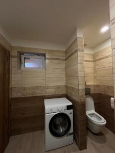 a bathroom with a washing machine and a toilet at Apartmany CityCentrum Trencin in Trenčín +11 photos