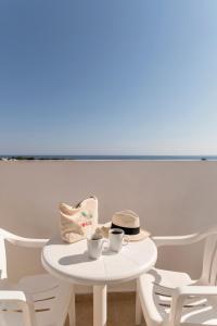a table with two cups and a hat and chairs at Stella Hotel in Pefki