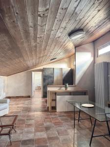 a kitchen with a wooden ceiling and a glass table at Hotel Urban By Giulia in Pozzolo Formigaro