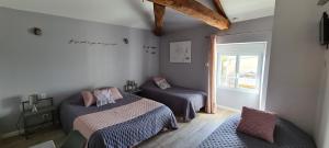 a bedroom with two beds and a window at A la Gloriette in Neuville-du-Poitou +27 photos
