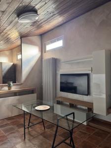 a living room with a glass table and a tv at Hotel Urban By Giulia in Pozzolo Formigaro +19 photos
