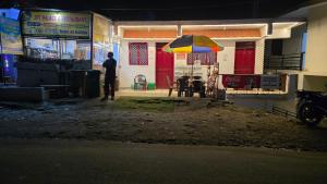 a man standing in front of a building with an umbrella at Hotel SPT Palace Phata in Phata