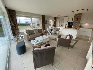a large living room with couches and a table at SunnySide-of-TheSea - stunning view on nature, big terraces all around - 150 m from sea, beach, stores, restaurants & beach bars - with parking in Nieuwpoort