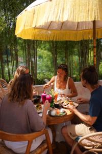 a group of people sitting around a table eating food at Porter Boutique Hotel & Lifestyle in Kuta Lombok +37 photos