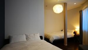 a bedroom with two beds and a mirror at Cloud House Sapporo in Sapporo