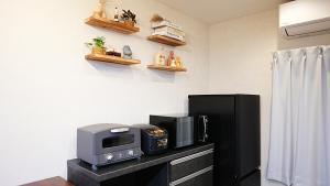 a kitchen with a black refrigerator and a microwave at Cloud House Sapporo in Sapporo