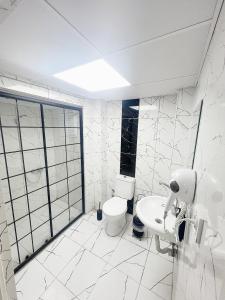 a white bathroom with a toilet and a sink at Karhal Room in Edirne