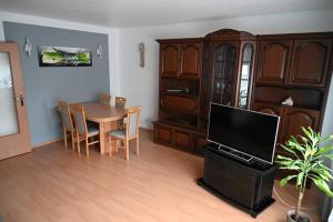 a living room with a dining room table and a tv at Ferienwohnung Lindlar in Lindlar