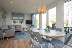a living room with a wooden table and chairs at Het Mienterbos in De Koog