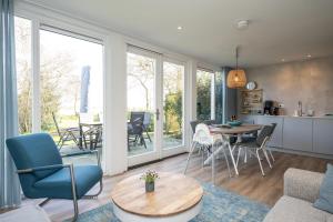 a kitchen and living room with a table and chairs at Het Mienterbos in De Koog