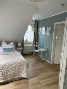 a bedroom with a bed and a desk and a window at Ferienwohnung Frers in Rallenbüschen