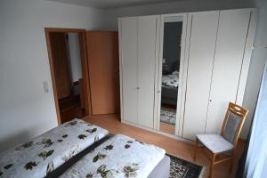 a bedroom with a bed and a chair and a mirror at Ferienwohnung Lindlar in Lindlar +8 photos