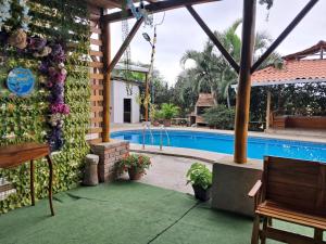 eine Terrasse mit Swimmingpool und ein Haus in der Unterkunft HostalElCascolManabiPuertolopez in Puerto López