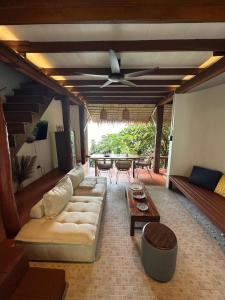 a living room with a couch and a ceiling fan at Suncliff Resort in Haad Rin