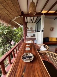 a wooden table sitting on a porch with chairs at Suncliff Resort in Haad Rin