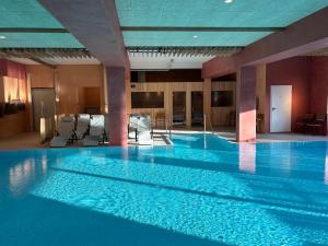 a large swimming pool in a hotel with blue ceilings at Carolinger Hüttendorf in Weyer