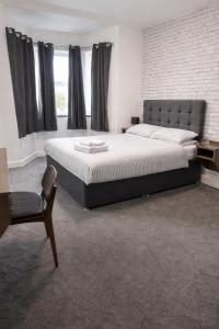 ein Schlafzimmer mit einem großen Bett und einem Stuhl in der Unterkunft Beverley Hotel in Walsall