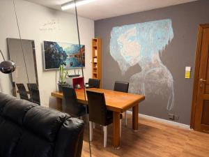 a dining room with a table and a painting on the wall at Perk25A in Steenokkerzeel