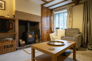 a living room with a couch and a fireplace at Mill Workers Cottage in Cromford