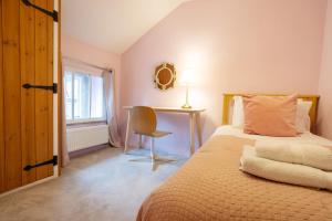 a bedroom with a bed and a desk and a chair at Mill Workers Cottage in Cromford