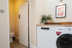 a laundry room with a washer and dryer at Mill Workers Cottage in Cromford +10 photos