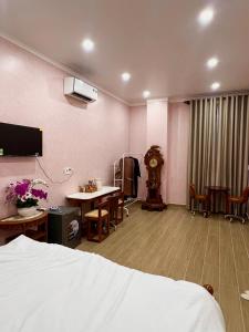 a room with a bed and a desk and a clock at Huỳnh Thảo in Vũng Liêm