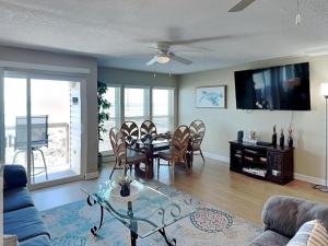 a living room with a table and chairs and a tv at Surfside Six E Unit 5 in St. Augustine