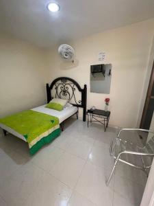 a bedroom with a bed and a tv and a chair at Hotel Morfeo in Tuluá