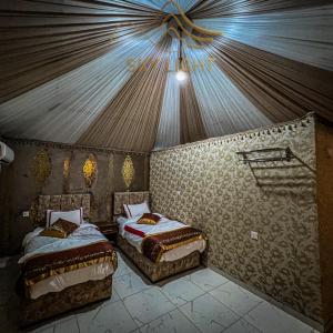 a bedroom with two beds in a tent at Skylight Wadi Rum Camp in Disah +4 photos