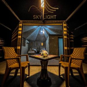 a table and two chairs in a room with a sky light at Skylight Wadi Rum Camp in Disah
