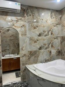 a bathroom with a sink and a tub and a mirror at Huỳnh Thảo in Vũng Liêm +18 photos