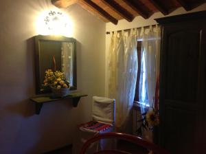 a room with a mirror and a window with a plant at Casa Vacanza La Ginestra Paciano in Paciano +22 photos