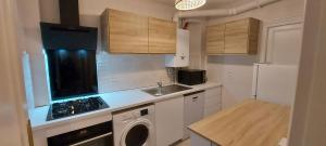 a small kitchen with a sink and a washer at Dieppe Appartement Vue plage et port in Dieppe