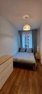 a bedroom with a bed and a chandelier at Dieppe Appartement Vue plage et port in Dieppe