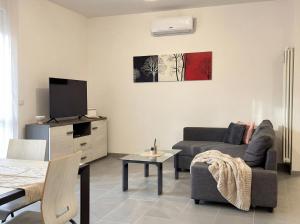 a living room with a couch and a tv at Suite Prisma - Modern & Spacious Apartment near Verona Fair in Verona +7 photos