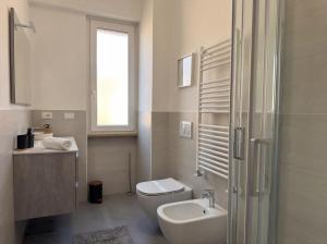 a bathroom with a toilet and a sink and a shower at Suite Prisma - Modern & Spacious Apartment near Verona Fair in Verona