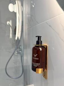 a bottle of soap next to a shower at RIOSHOUSE Henley in Henley on Thames