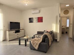 a living room with a couch and a tv at Suite Prisma - Modern & Spacious Apartment near Verona Fair in Verona
