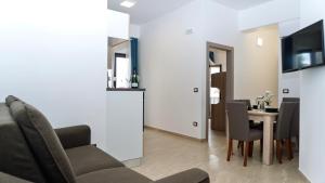 a living room with a couch and a table with chairs at Kalispera Residence in Scalea