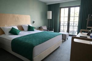 a bedroom with a large bed with a green blanket at Błażejewko Resort in Błażejewko +57 photos