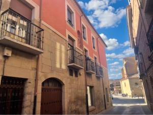 a brick building with balconies on a street at Casa Pepa in Fuenmayor