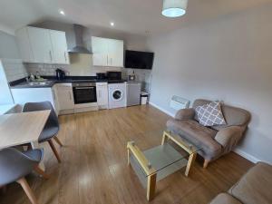 a living room with a couch and a kitchen at 4a Smart Apartments in Newark-on-Trent +43 photos