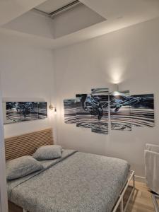 a bedroom with a bed and some pictures on the wall at Maison chaleureuse jacuzzi PS2-1, climatisation et parking payants in Bagneux