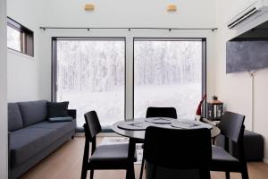 a living room with a couch and a table with chairs at Aurora Paradise Levi Iglu in Levi