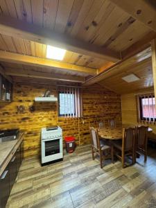 a kitchen and dining room with a table and a stove at Zaovinski Raj2 Tara in Konjska Reka