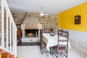 a dining room with a table and a fireplace at Casa Cabreiros de Baixo in Melgaço